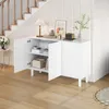 A white sideboard with open doors, revealing shelves with books and decorative items, placed in a hallway next to a staircase. Voir les images du produit