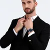 A man in a suit adjusting his shirt collar, wearing a watch. Náhled obrázku produktu
