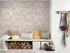 A cozy entryway with a bench, firewood, pillows, and a coat rack. Produktbild-Vorschau