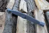 A dark gray metal object rests on a pile of chopped firewood. Náhled obrázku produktu