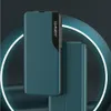 A teal-colored flip case for a Samsung S24 Ultra is displayed against a dark background with a glowing white circular element. Anteprima dell’immagine prodotto