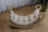 A Montessori-style rocking chair with a beige cushion on a wooden floor, with sheer curtains in the background. Produktbild-Vorschau