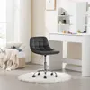 A dark gray office chair with wheels sits on a white fluffy rug in front of a white vanity desk. Náhľad obrázku produktu