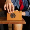 A hand is shown adjusting a portable cassette player on a wooden table. Náhled obrázku produktu