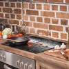 A kitchen counter with a stovetop, cooking utensils, and ingredients. Produktbild-Vorschau