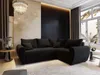 A modern black sectional sofa in a well-decorated living room.