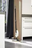 A steam mop stands upright on a tiled floor in a modern kitchen setting. Voir les images du produit