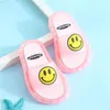 Paar pinke Sarangue-Rutschen mit gelben Smileys auf den Riemen, auf hellblauer Oberfläche mit weißem Rahmen und blauem Seestern Náhled obrázku produktu