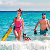 A man and a woman are walking in the ocean with snorkeling gear. Podgląd zdjęcia produktu