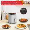 A kitchen counter scene featuring a white air fryer, food on plates, and kitchenware in the background. Produktbild-Vorschau