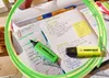 A desk with study materials, including notebooks, pens, and highlighters. Anteprima dell’immagine prodotto