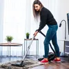 A woman vacuuming a rug in a well-lit room. Náhľad obrázku produktu