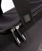 A close-up view of a black duffel bag, focusing on the zippers and strap. Voir les images du produit