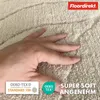 A hand is shown pressing into a soft, textured bath mat. Logos and text indicating product features are overlaid on the image. Anteprima dell’immagine prodotto