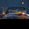 A bedroom scene with a bed dressed in a forest-themed duvet cover. Voir les images du produit