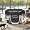 A portable pet playpen is set up on a rug in a modern living space, with several dogs around it. Produktbild-Vorschau