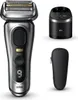 A silver and black electric shaver with its charging base and travel case, displayed on a white background. Produktbild-Vorschau
