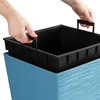 Hands are shown inserting a black plastic liner into a blue planter. Voir les images du produit