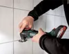 A person is using a Metabo multitool to cut grout between tiles. Náhľad obrázku produktu