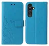 A blue flip phone case with a floral and butterfly embossed design is shown open, displaying the inside and the outside of the case. Produktbild-Vorschau