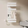 A white electric towel warmer mounted on a light beige wall in a bathroom setting. Náhľad obrázku produktu