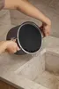 A person is pouring water from a pot into a sink. Podgląd zdjęcia produktu