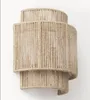 A wall lamp made of jute rope, mounted on a white wall. Voir les images du produit