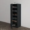 A tall, narrow shoe cabinet with multiple shelves, filled with various shoes. The cabinet is dark gray and stands against a light gray wall, with a wooden floor in the foreground. Produktbild-Vorschau