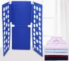 A blue folding board for clothes is shown next to a stack of folded shirts. Podgląd zdjęcia produktu
