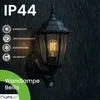 A black outdoor wall lamp with a vintage Edison-style bulb, shown in the rain. Produktbild-Vorschau
