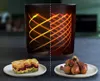A split image showing a cooking appliance with a graphic representation of heat flow, and two plates of food: one with lasagna and the other with chicken drumsticks. Podgląd zdjęcia produktu