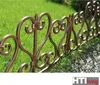 A decorative metal fence bordering a lawn and gravel path. Produktbild-Vorschau