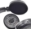 A close-up view of headphone ear pads and a detached ear cushion, showing the internal foam and mounting structure. Produktbild-Vorschau