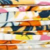 A stack of folded fleece blankets with a colorful floral pattern. Náhled obrázku produktu