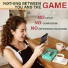 A woman is happily looking at a handheld gaming console while sitting at a table with coffee. Produktbild-Vorschau