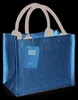 A blue jute gift bag with beige handles and a tag. Voir les images du produit