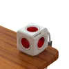 A white PowerCube Extended power strip with red outlets sits on a wooden table. Produktbild-Vorschau