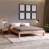 A bedroom scene featuring a wooden bed frame with bedding, a nightstand, lamps, and artwork on the wall. Produktbild-Vorschau