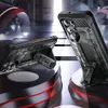 Two phone cases with kickstands are displayed on a futuristic, abstract platform with red and black accents. Produktbild-Vorschau