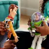 Two Toy Story action figures, Woody and Buzz Lightyear, are being held by unseen people. Náhľad obrázku produktu
