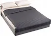A weighted blanket is laid out on a bed with two pillows. Podgląd zdjęcia produktu
