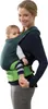 A woman is wearing a baby carrier with a baby in it. Produktbild-Vorschau