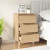 A wooden nightstand with three drawers next to a bed. Náhled obrázku produktu