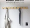 A wooden wall-mounted coat rack with two items hanging on it. Produktbild-Vorschau