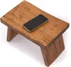 A wooden stool with a smartphone on top, isolated on a white background. Produktbild-Vorschau