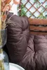 A close-up view of a brown cushion on a wooden bench, with some dried flowers in a vase in the foreground. Anteprima dell’immagine prodotto
