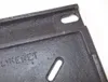 A close-up view of a black metal grate with embossed text. Náhľad obrázku produktu