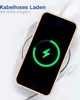 A smartphone is placed on a wireless charger, displaying a charging animation on its screen. The phone has a pink case. Produktbild-Vorschau
