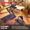 A woman is doing yoga next to a treadmill in a living room. Produktbild-Vorschau