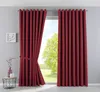 A room with a window covered by red curtains, with a small table and vase on the side. Produktbild-Vorschau